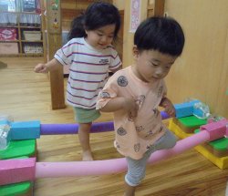 今度はスティックを跨ぎます　片足で体を支える力がついているよ